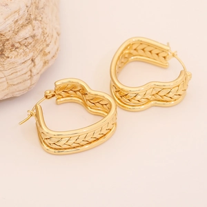 Pair of gold braided heart earrings with intricate woven texture on beige background