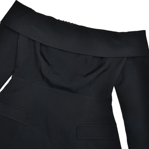 Detail view of black off-shoulder dress featuring structured blazer style and faux pockets
