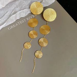 Detail of gold circular textured drop earrings with cascading long metal fringe design
