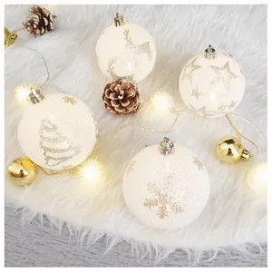 Detail of frosted white Christmas ornaments with silver reindeer and star patterns on plush rug