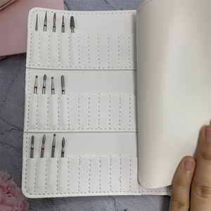 White faux leather nail drill bit organizer case with 37 slots and various bits inside