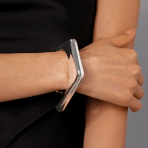 Close-up of polished silver irregular geometric cuff bracelet worn on a female wrist