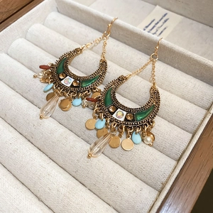 Detailed shot of Bohemian moon earrings with green enamel and blue teardrop beads