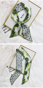 Detailed view of green and white printed silk hair scarf tied on a white shirt