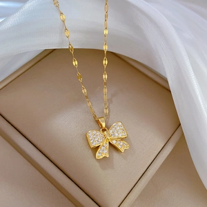 Vue détaillée d'un pendentif nœud doré serti de cristaux sur un coffret à bijoux