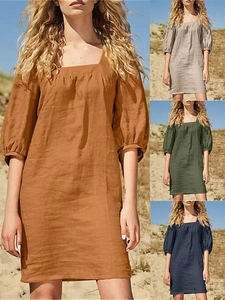 Detail showing various colors of French square neck linen dresses in a beach setting