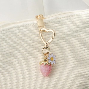 Sweet strawberry heart keychain with daisy charm on a woven bag zipper pull