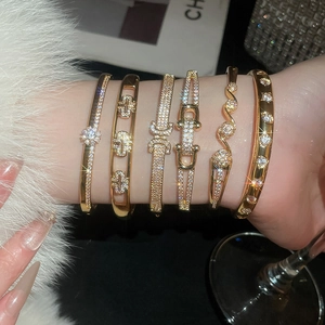Gros plan de bracelets géométriques plaqués or avec zircons cubiques sur un poignet