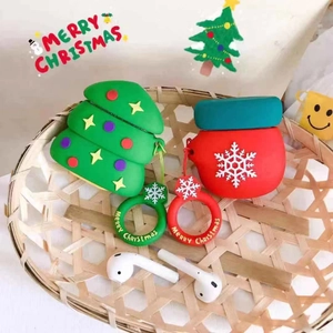 Vue détaillée des étuis AirPods en silicone sapin et chaussette de Noël dans un panier