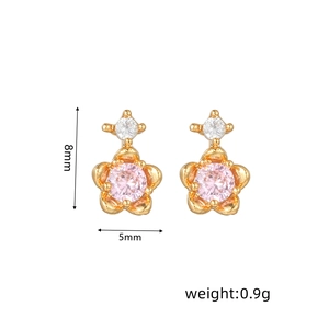 Detalle de aretes de flor de 8mm con gema rosa y chapado en oro de 18k