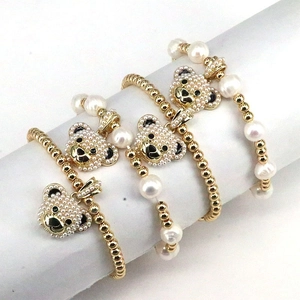 Detail view of pearl bracelets with gold beads and micro-paved bear pendants
