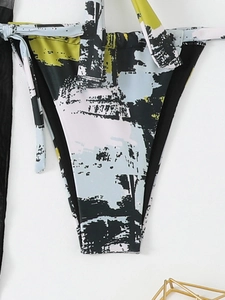 Detail of high-cut bikini bottoms featuring side ties and abstract geometric print