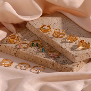 Détail de bagues empilables plaquées or 18K avec zircons colorés sur socle en pierre