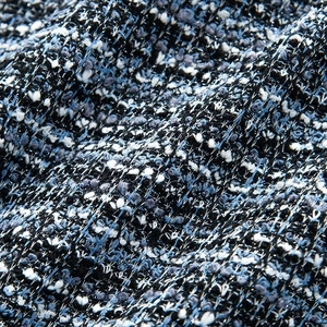 Vue macro du tissu en tweed bleu et noir montrant la texture tissée sophistiquée