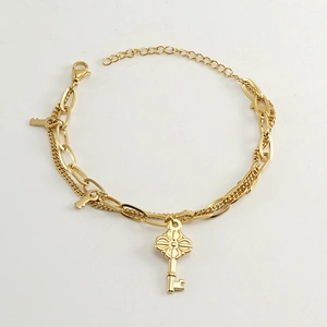 Detail of gold double-layer chain bracelet featuring floral key pendants and lobster clasp