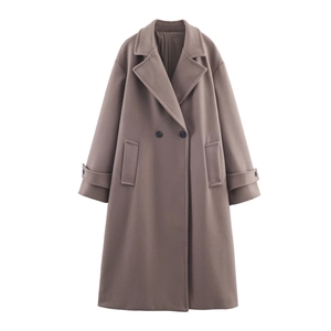 Détail d'un manteau en laine taupe avec boutons croisés et grandes poches latérales