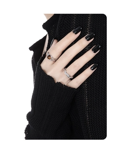 Detailed view of irregular silver rings on model hand featuring amber gemstone insert