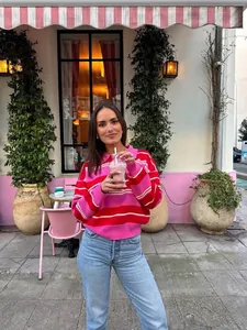 Women's pink and red striped polo collar sweater with long sleeves and knit fabric