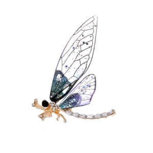 Close-up of a golden dragonfly brooch with sparkling rhinestones and gradient wings