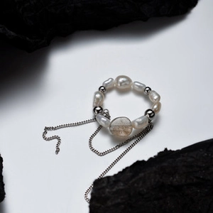 Macro detail of S925 sterling silver ring with freshwater pearl and fringe metal chains