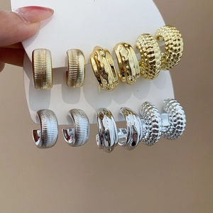 Detailed set of six pairs of C-shaped acrylic earrings with diverse metallic textures