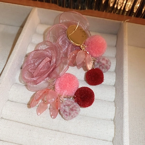 Pink fabric floral earrings with soft plush pom-poms and gold accents in jewelry box