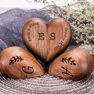 Detail of heart-shaped walnut wood ring box featuring personalized names and date engraving