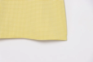 Detail of yellow and white gingham seersucker fabric with breathable textured weave
