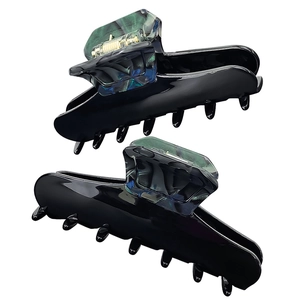 Macro detail of large black acetate hair claw clips with marble texture and gold spring