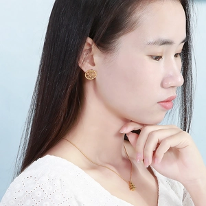 Close-up of elegant gold hollow circle earrings and layered necklace worn by a model