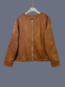 Detalle de una chaqueta de gamuza marrón con cremallera metálica y dobladillo elástico