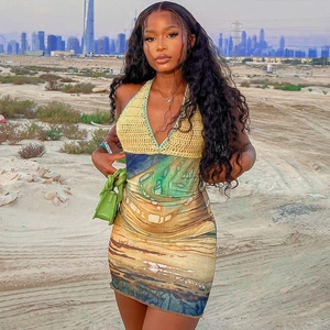 Deep V-neck crochet halter dress with desert print skirt against sand dunes