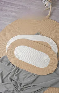 Detail of handwoven oval cotton rug showing soft texture and natural spiral braid pattern