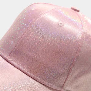 Macro shot of pink glitter baseball cap showing shiny fabric texture and neat stitching details