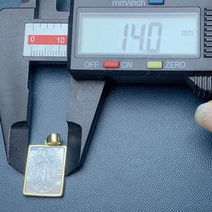 Digital caliper measuring the 14mm width of a square Guadalupe mother of pearl pendant