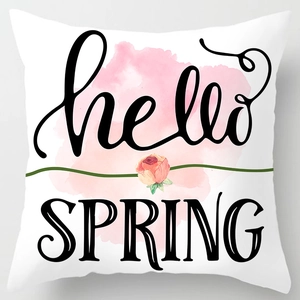 Close-up of white cushion cover with Hello Spring floral design and pink watercolor rose
