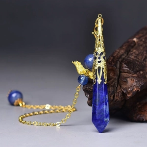 Detail of lapis lazuli hexagonal prism pendant with gold hollow patterned cap and chain