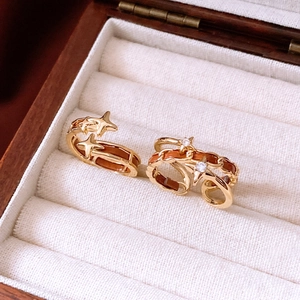 Detail of vintage gold star rings with leather texture in a wooden jewelry box