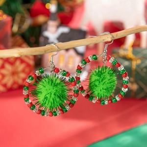 Christmas wreath earrings with green pom-poms and colorful beads on a festive wooden branch