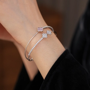 Close-up of double-layer silver bangle with pink and white zircon four-leaf clover details