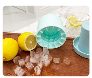 Blue silicone cylinder ice cube mold on wooden board with fresh lemons and cold drink