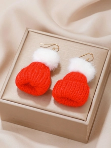 Detail of red and white knitted Christmas hat earrings with soft white pom poms