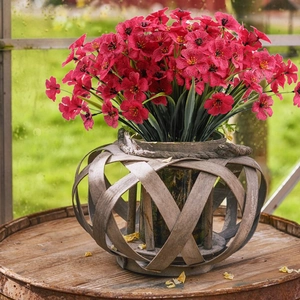 Close-up of red artificial violets in a woven wooden basket for porch decoration