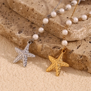 Starfish pendant necklaces in gold and silver with white pearls on a textured background