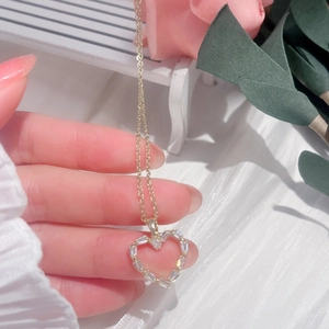 Golden heart-shaped necklace with sparkling zircon pavé on a minimalist chain