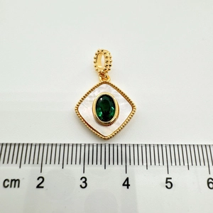 Measurement of a gold square shell pendant with a green oval gemstone and a ruler
