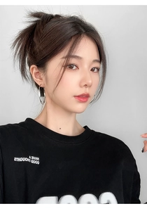 Detail of a model wearing large silver geometric hoop earrings with a black slogan T-shirt