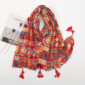Macro detail of red ethnic print shawl with geometric patterns and tassel fringe