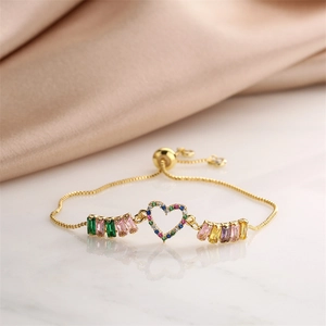 Macro detail of adjustable heart bracelet with colorful cubic zirconia on silk background