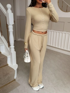 Detail of beige two-piece lounge set with button cardigan and elastic drawstring pants